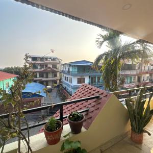 a balcony with plants and a view of a city at A Cube Homestay in Bharatpur