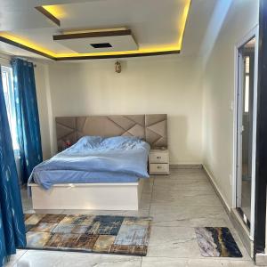 a bedroom with a bed with a blue comforter at A Cube Homestay in Bharatpur