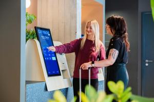 two women standing in front of a computer screen at Citybox Bergen Danmarksplass in Bergen