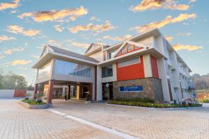 a building on a street with a cloudy sky at Omkar Jungle Resort & Spa, Sirsi in Islūr