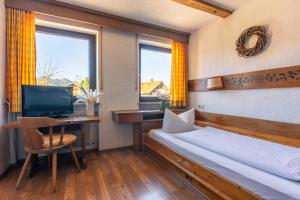a bedroom with a bed and a desk with a computer at Der Bären in Zell in Eisenberg