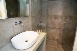 a bathroom with a white sink and a shower at Megara Hotel in Megara