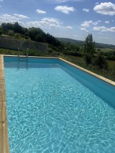a large blue swimming pool with a view at Private gîte with stunning views & shared pool in Laussou +1 photo
