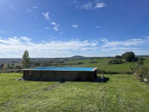 a building in the middle of a field at Private gîte with stunning views & shared pool in Laussou