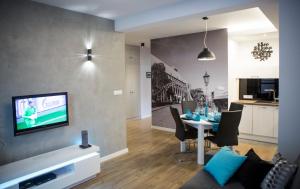 Televízia a/alebo spoločenská miestnosť v ubytovaní Apartament Bridge