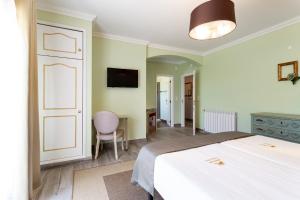 a bedroom with a bed and a tv and a chair at Quinta Sao Martinho in Reguengo Grande