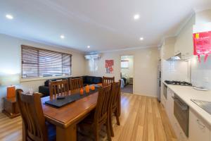 a kitchen and dining room with a wooden table and chairs at Fossickers Tourist Park in Nundle