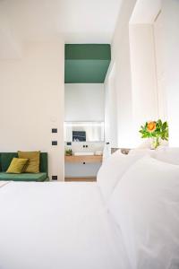 a white bedroom with two beds and a couch at ARIA Collection Bari in Bari