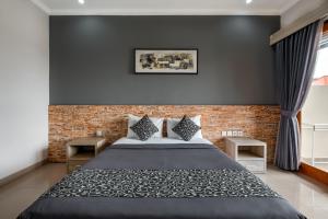 a bedroom with a bed and a brick wall at D Sarian Seminyak in Seminyak
