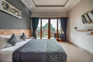 a bedroom with a large bed and a balcony at D Sarian Seminyak in Seminyak