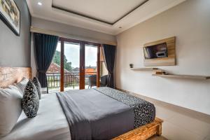 a bedroom with a bed and a large window at D Sarian Seminyak in Seminyak