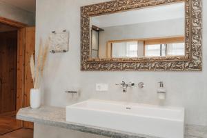 a bathroom with a white sink and a mirror at Luxus Seaside Loft in Füssen +42 photos