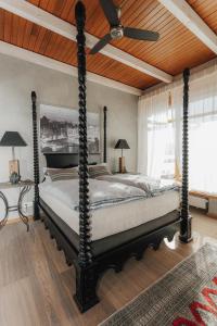 a bedroom with a four poster bed with a wooden ceiling at Luxus Seaside Loft in Füssen