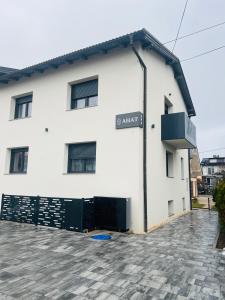 a white building with a sign on the side of it at Ahat apartment- Modern stay near center & free parking in Maribor
