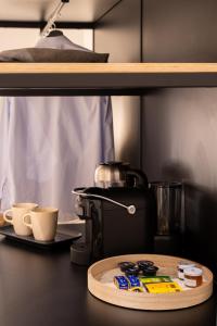 a table with a coffee maker and cups on a shelf at ARIA Collection Bari in Bari