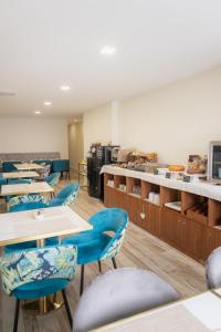 a dining room with tables and blue chairs at Art'Otel Barcelos in Barcelos