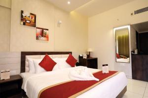 a hotel room with a large bed with red pillows at The White Pearl Suites in Bangalore