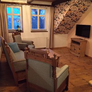 a living room with two chairs and a television at Darpvenner Diele in Ostercappeln
