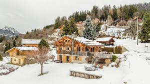 a large wooden house in the snow at Atalaya Chalet - Panoramic View in Saint-Jean-de-Sixt