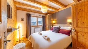 a bedroom with a large white bed and a window at Atalaya Chalet - Panoramic View in Saint-Jean-de-Sixt