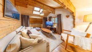 a living room with a large couch and a tv at Atalaya Chalet - Panoramic View in Saint-Jean-de-Sixt