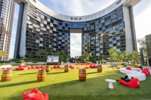 a building with red bean bags on the grass in front of a building at Queens Wharf 1B plus Study apt - level 29 City view in Brisbane