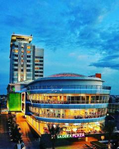ein großes Gebäude mit Licht vor einem Gebäude in der Unterkunft FOX Hotel Pekanbaru in Pekanbaru