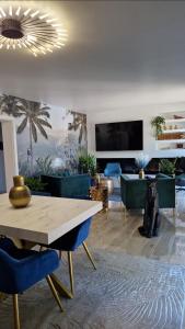 a living room with a table and blue chairs at Le Peekskill in Montbron