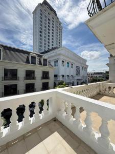 a balcony with a white railing and a tall building at Kim Phung Homestay in Dong Hoi