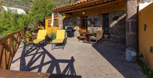 a patio with chairs and a table and a building at Casa Rural - Cottage Bentayga in Tejeda
