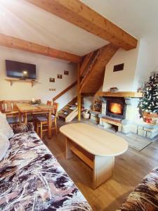 a living room with a table and a fireplace at Privát NA CHALUPE Partizánska Ľupča 649 in Partizánska ľupča