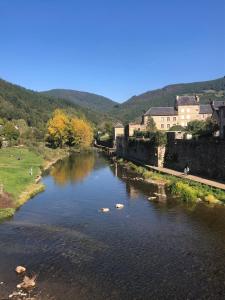 a river with rocks in the water next to buildings at Maisonnette dans son écrin de verdure in Saint-Geniez-dʼOlt