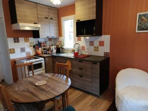 a small kitchen with a wooden table and a dining room at Maisonnette dans son écrin de verdure in Saint-Geniez-dʼOlt