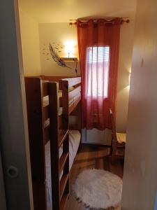 a small room with bunk beds and a window at Maisonnette dans son écrin de verdure in Saint-Geniez-dʼOlt +2 photos