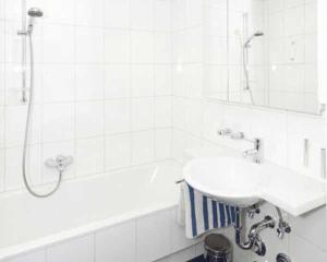 a white bathroom with a sink and a bath tub at Tonis Appartement in Schruns +57 photos