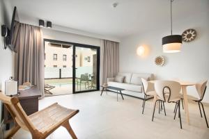 a living room with a table and chairs and a couch at Hotel Coral Cotillo Reef in El Cotillo
