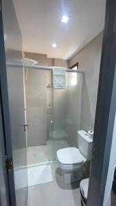 a bathroom with a toilet and a glass shower at Seu Hotel in Patos
