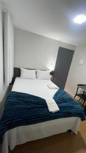 a bedroom with a large bed with a blue blanket at Seu Hotel in Patos +18 photos