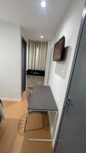 a room with a table and a tv on a wall at Seu Hotel in Patos