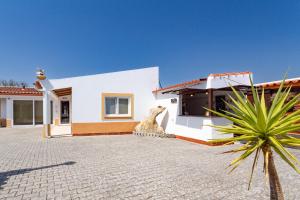 a white house with a statue of a camel outside at Quinta Sao Martinho in Reguengo Grande