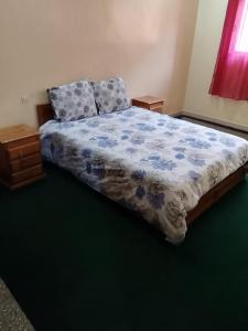 a bedroom with a bed with a blue comforter at Razzak in Rabat