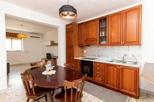 a kitchen with wooden cabinets and a wooden table at Villetta Degli Aranci in San Foca