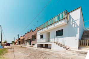 a building with stairs on the side of a street at Villetta Degli Aranci in San Foca