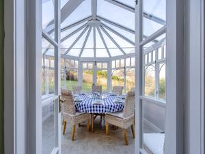 a dining room with a table and chairs in a conservatory at Ladywell House in Falkland