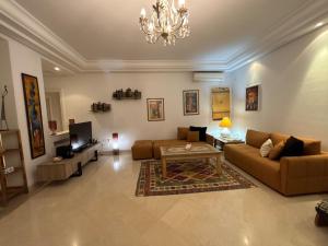 a living room with two couches and a tv at Maison casa bloom - La marsa in Bin Rhilouf