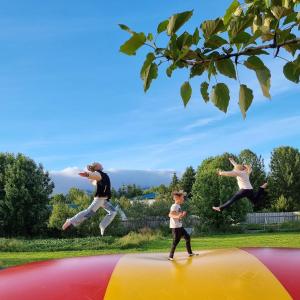 a man and a boy jumping on a trampoline at Miðhraun - Lava resort & Restaurant in Midhraun