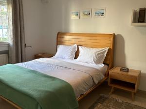 a bedroom with a bed with a wooden headboard at Maison casa bloom - La marsa in Bin Rhilouf