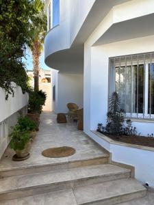 a hallway of a house with stairs and plants at Maison casa bloom - La marsa in Bin Rhilouf