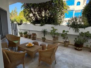 a patio with a table and chairs and potted plants at Maison casa bloom - La marsa in Bin Rhilouf