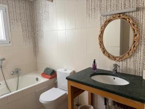 a bathroom with a sink and a toilet and a mirror at Maison casa bloom - La marsa in Bin Rhilouf +29 photos
